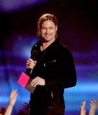 Brad Pitt wearing a John Varvatos Collection Suede Shirt Jacket with snap button closure and zip pocket details.