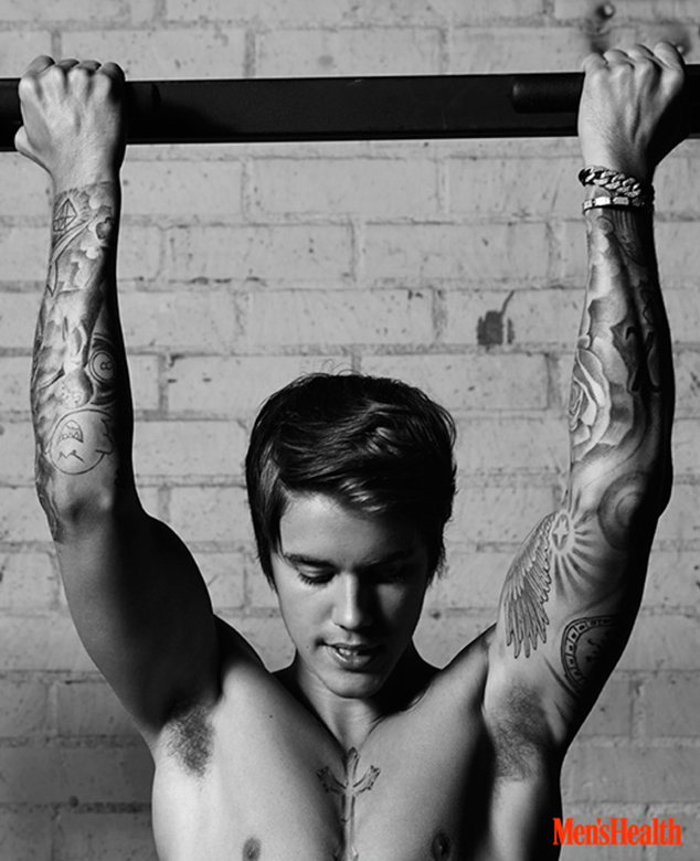 Justin Bieber does a pull-up. 