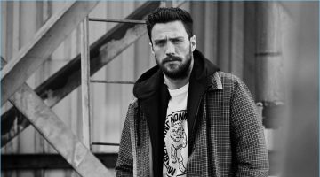 Aaron Taylor-Johnson sports a Prada checked wool coat with a Vetements + Champion hoodie and a Stella McCartney graphic t-shirt.