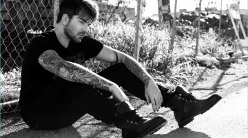 Adam Lambert wears a Cult of Individuality t-shirt and jeans with COS boots.