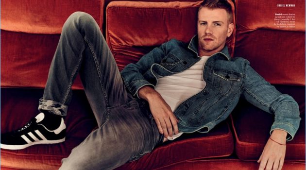 Relaxing, Daniel Newman wears a t-shirt and denim jacket by Diesel. He also sports 7 For All Mankind jeans and Adidas sneakers.