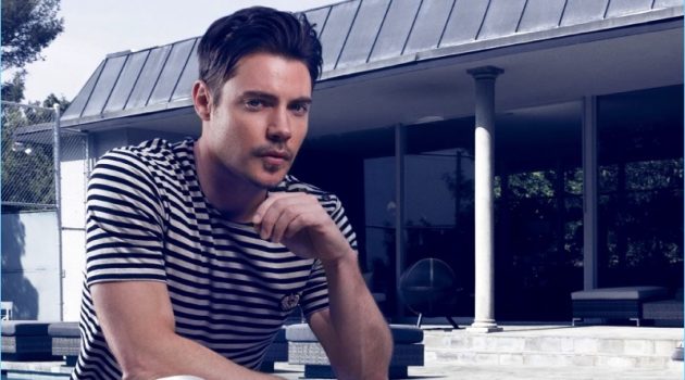 Relaxing outdoors, Josh Henderson wears a striped tee by The Kooples with AllSaints jeans, and Joseph Abboud dress shoes.