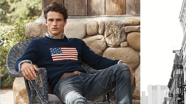 Simon Nessman relaxes in POLO Ralph Lauren's iconic flag sweater $225. He also wears the label's Sullivan slim stretch jeans $198.