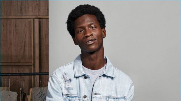 Connecting with H&M, Adonis Bosso wears a denim jacket, sweatshirt, and white skinny jeans.