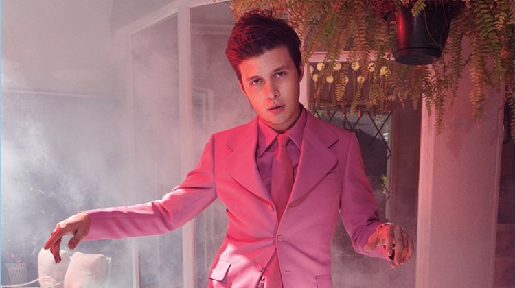 Showcasing his best dance moves, Nick Robinson wears a pink Gucci suit, shirt, and tie.