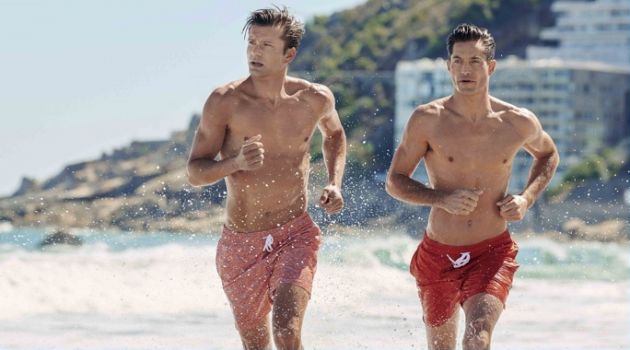 Models George Paul and Greg Kheel hit the beach in swim shorts from Derek Rose's resort 2018 collection.