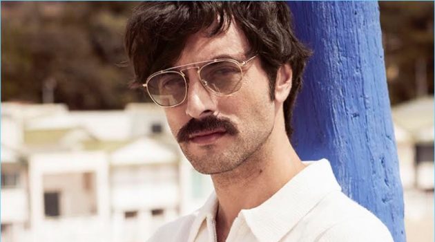 A summer vision, Javier Rey dons a Sandro polo, BOSS pants, a Hermès watch, and Lozza sunglasses.