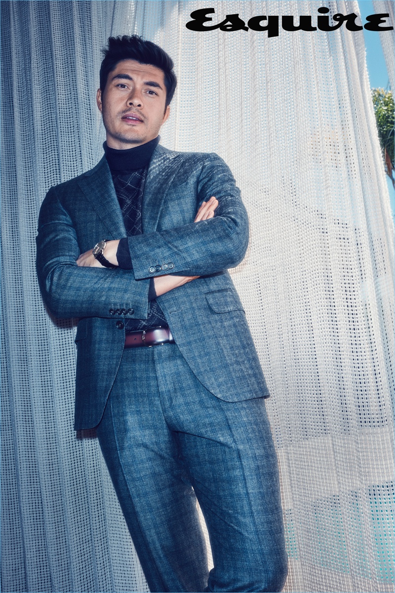 Crazy Rich Asians star Henry Golding dons a turtleneck sweater, suit, and belt by Canali. He also wears a Glashütte watch.