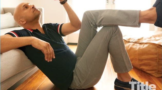 Relaxing, Keegan-Michael Key dons a Burberry polo, Citizens of Humanity pants, Baldinini sneakers, and a Goorin Bros. hat.