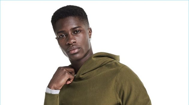 Model James Kakonge rocks a Todd Snyder + Champion hoodie with Todd Snyder corduroy trousers.