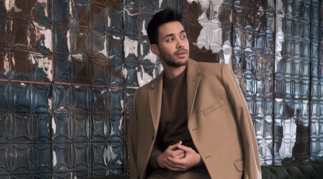 Singer Prince Royce dons a wool-blend camel coat with a fine-knit sweater, and suit pants by H&M.