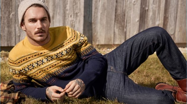 Relaxing, David Alexander Flinn wears a LE 31 Scandinavian jacquard sweater and knit beanie with Levi's deep indigo 511 jeans.