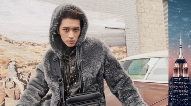 Timmy Xu dons a reversible shearling hoodie in dark grey for Coach's holiday 2018 campaign.