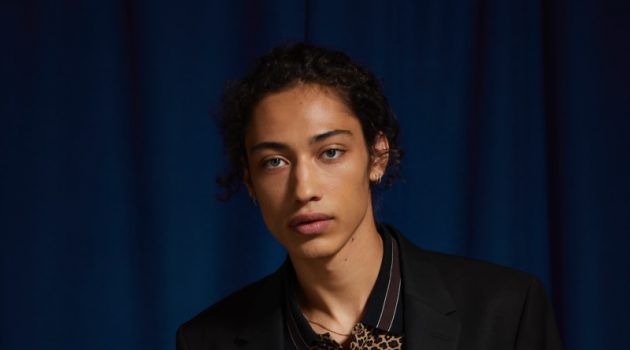 Max Fieschi models an UO black skinny fit blazer and suit pants with a Lacoste leopard print polo.