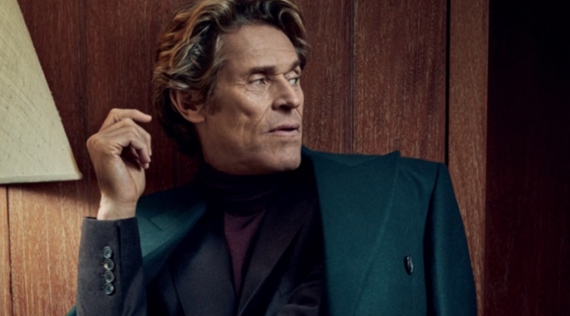 A sleek vision, Willem Dafoe wears a Paul Smith double-breasted coat with a sweater and suit by Gieves & Hawkes.