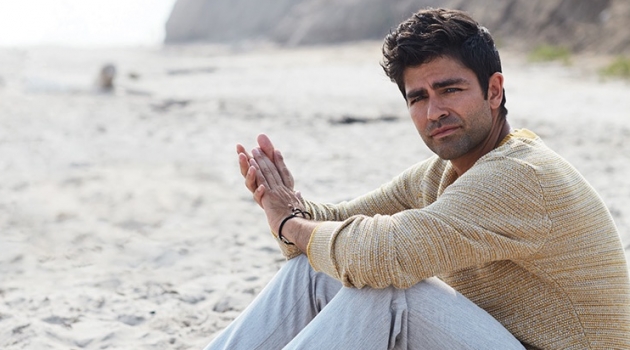 Taking to the beach, Adrian Grenier wears a Selected Homme sweater and life/after/denim trousers.