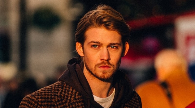 Captured out and about, Joe Alwyn dons an Incotex houndstooth coat, Fendi hoodie, and Mr P. t-shirt.