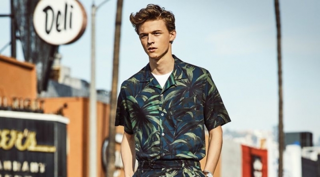 Making a tropical statement, Max Barczak dons a Todd Snyder olive palm print camp collar shirt and shorts.