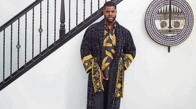 Winston Duke wears a Versace bathrobe, Dolce & Gabbana shirt, Saturdays New York sweatpants, and Falke socks.