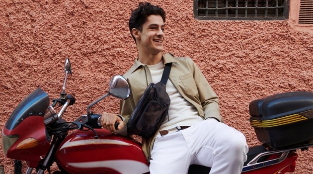 All smiles, Cyrus Amini wears Banana Republic's Core Temp coach's jacket $149, chinos $98, suede loafers $148, and a camouflage print belt bag $59.50.