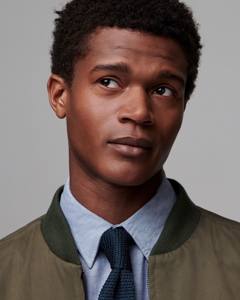 Front and center, O'Shea Robertson models a bomber jacket, shirt, and tie from Jigsaw's fall-winter 2019 men's collection.