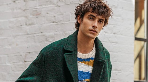 Oscar Kindelan dons a green coat with a graphic sweater from Reserved.