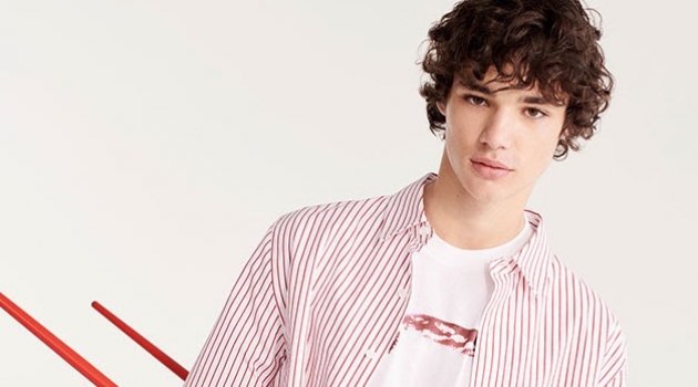 Connecting with YOOX, Fernando Lindez wears a red and white striped shirt with a graphic tee.