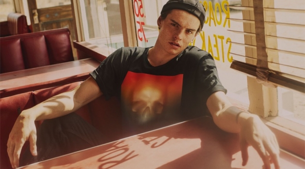 Gabriel Jayne wears a graphic t-shirt, beanie, and black slim-fit jeans from Zara.