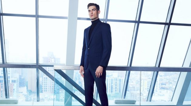 Jason Anthony dons a navy BOSS suit with a black turtleneck for Bloomingdale's.