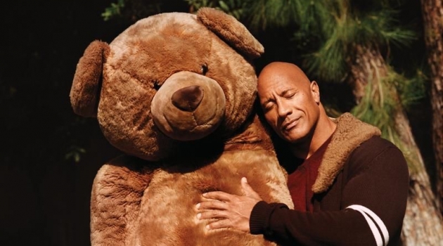 Hugging a giant teddy bear, Dwayne "The Rock" Johnson sports a Dolce & Gabbana cardigan, Brioni sweater, and Double RL jeans for WSJ. magazine.