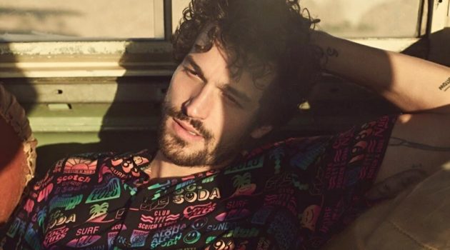 Enjoying a warm day's sun, Paul Kelly appears in Scotch & Soda's spring-summer 2020 campaign. He relaxes in the brand's printed viscose shirt.