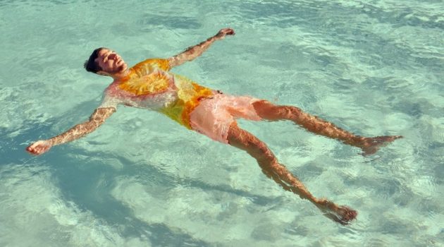 Relaxing in the pool, Arran Sly sports a tie dye t-shirt with garment dyed swim shorts from Scotch & Soda.