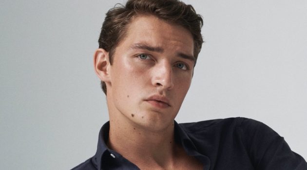 Model Otto Lotz dons a Massimo Dutti slim-fit cotton twill shirt with slim-fit denim-effect trousers.