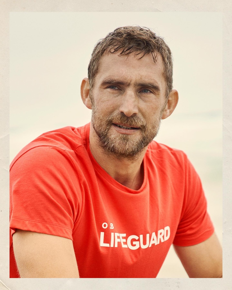 Front and center, Will Chalker models a rescue red lifeguard slogan t-shirt.
