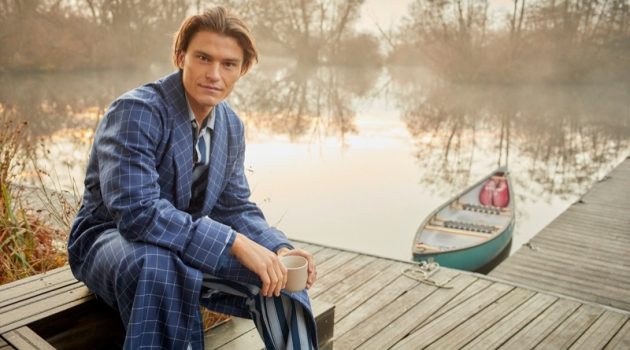 Connecting with Derek Rose for the season, Oliver Cheshire dons a men's navy check tasseled belt robe in pure wool with a striped pajama set.