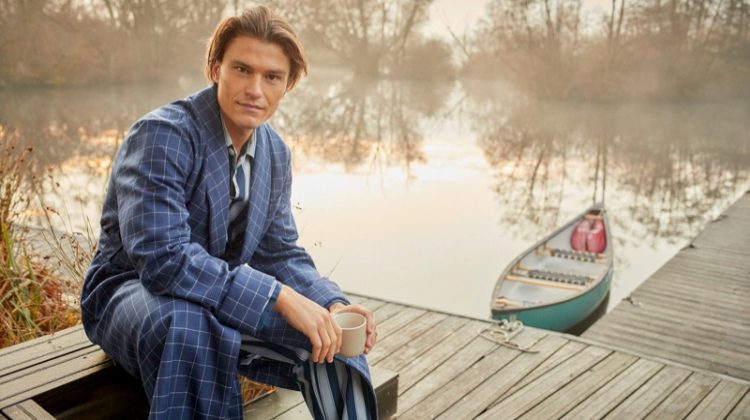 Connecting with Derek Rose for the season, Oliver Cheshire dons a men's navy check tasseled belt robe in pure wool with a striped pajama set.