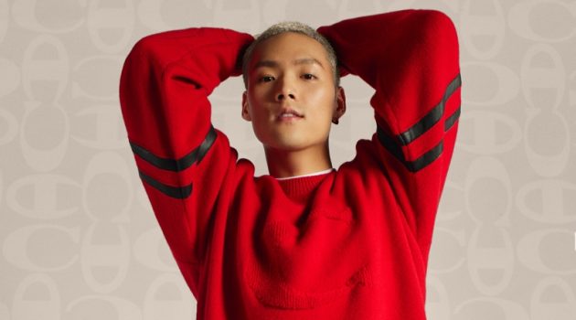 Jeffrey Tung sports a red pullover and black joggers from the Coach x Champion collection.