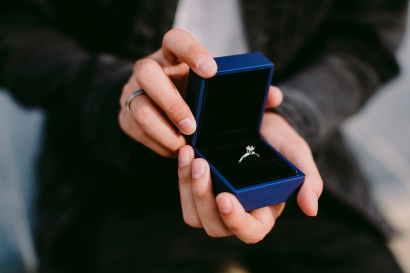 Man Holding Blue Engagement Ring Box 