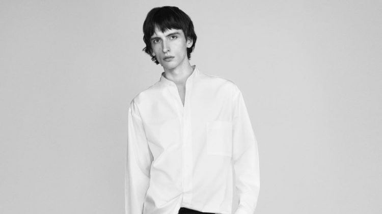 Benno Bulang dons a crisp white band-collar shirt with black trousers for UNIQLO +J's spring 2021 campaign.