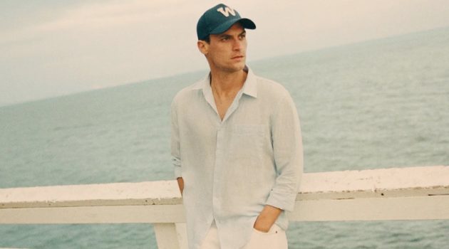 Donning sleek summer style, Miles Garber wears a linen shirt and white pants from Zara.