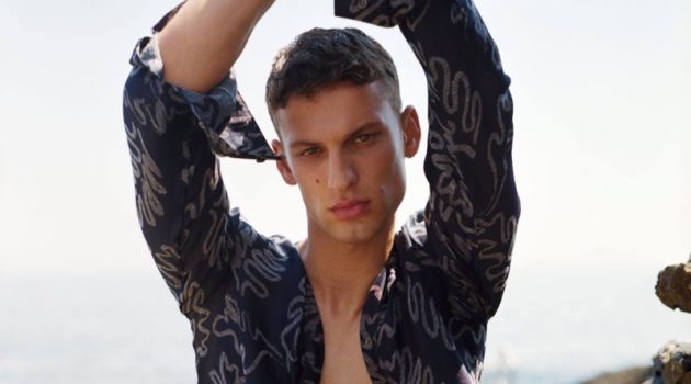 Sporting an open printed shirt, David Trulik stars in Giorgio Armani's summer 2021 men's campaign.