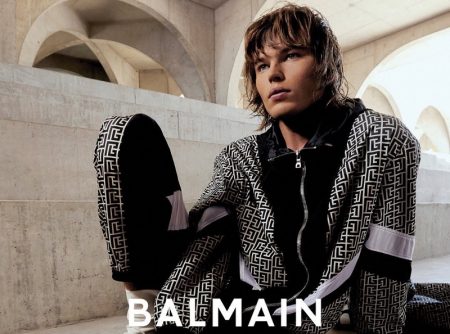 Jordan Barrett sports a black and white tracksuit as the star of the Balmain Paris Hair Couture fall-winter 2021 campaign.