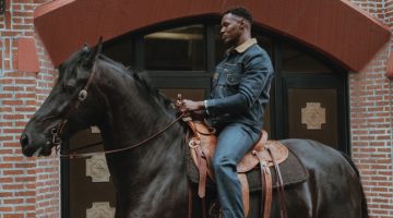 Riding a horse, Christopher Gary Lawson sports a denim look from the new Lee x The Brooklyn Circus collection.