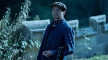 Pictured as Oliver Mellors in Lady Chatterley’s Lover, Jack O'Connell wears a blue chore jacket with a flat cap.