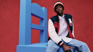 Sitting on an oversized chair, Babacar N'Doye sports a varsity jacket, knit beanie, and jeans from the Tommy Hilfiger x Miffy collection.