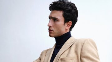 Mattia Narducci inspires in a sleek tan-colored double-breasted coat with a black turtleneck and navy trousers.