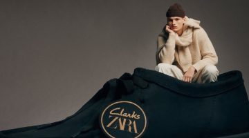 Model Louis Göckenjan poses inside an oversized leather shoe for the Clarks x Zara collection.