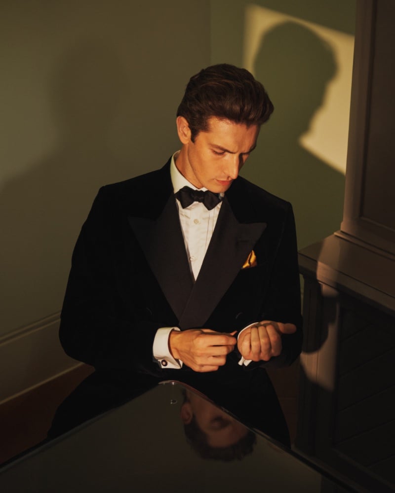 Oli Lacey adjusts his sleeves, his Dunhill attire a seamless blend of tradition and contemporary class. 