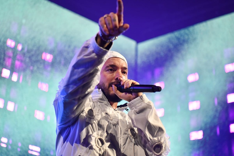 J Balvin engages the audience, wearing a unique white jacket, performing at the G-SHOCK 40th anniversary celebration.