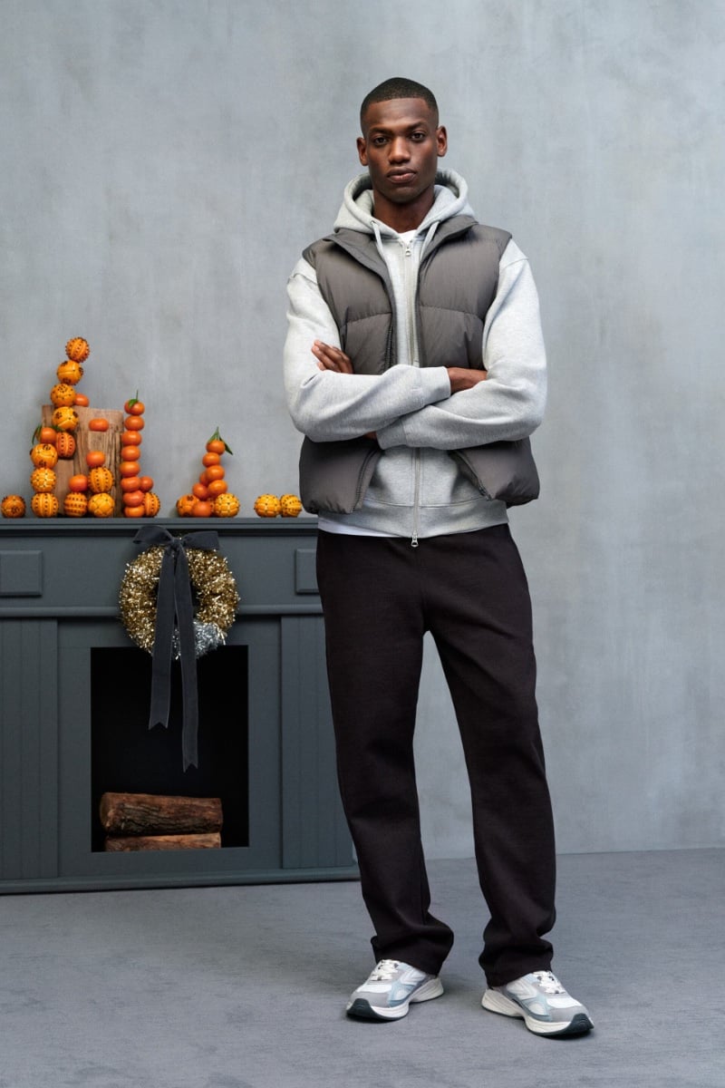 Bambi Kouyate demonstrates sports casual style in a grey hooded sweatshirt and puffer vest.